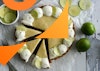 vegan key lime pie with 3 slices pulled out, surrounded by forks, lime, and lime slices