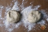 2 ravioli dough balls, divided, on a floured piece of parchment paper