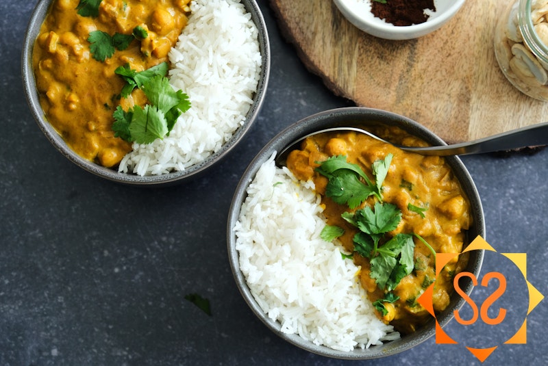 Two bowls of chickpea curry closeup with rice