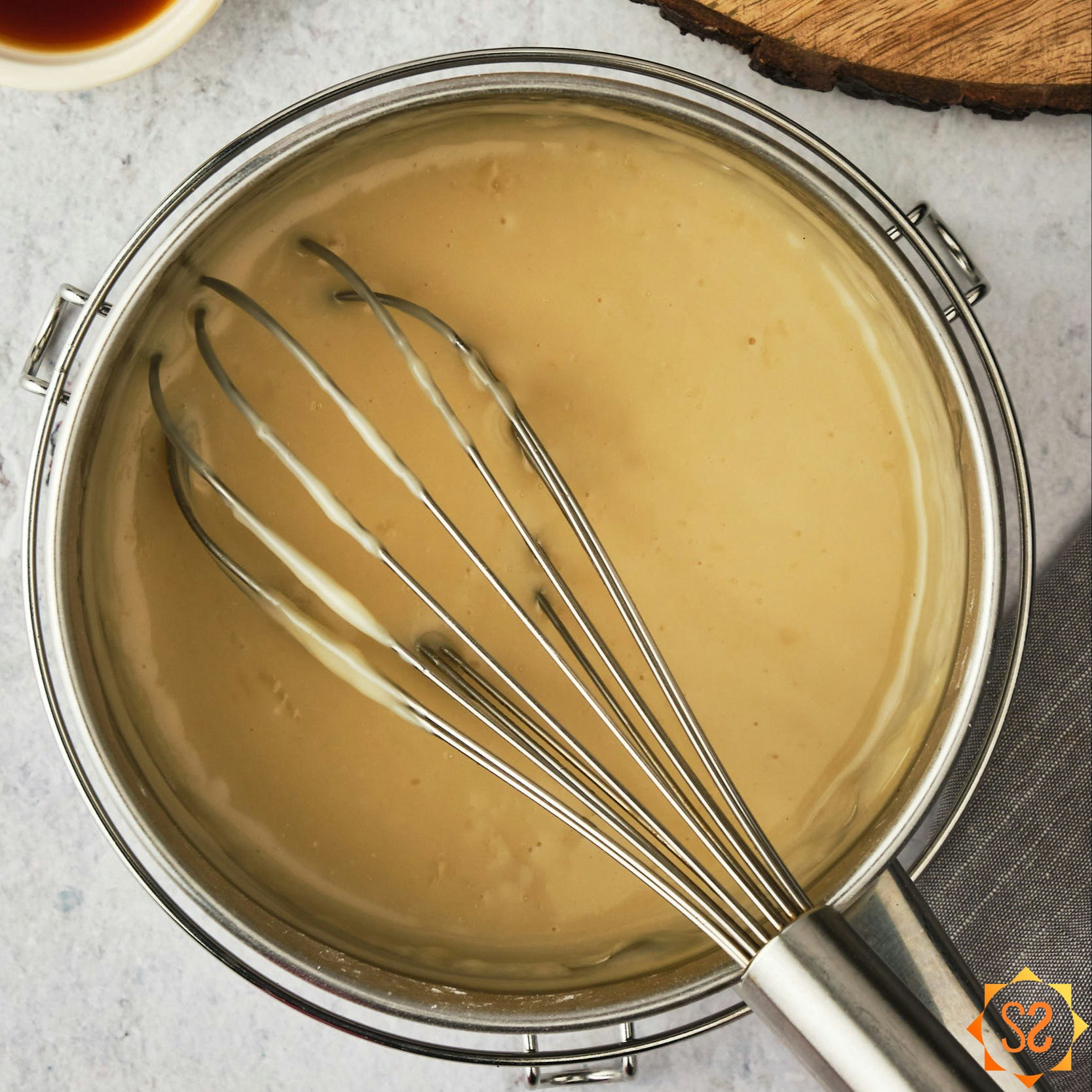 Vegan Vanilla Pudding, thickened in a pan with a whisk. 
