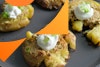 close up view of smashed potato with sour cream and green onion