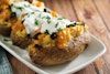Vegan loaded baked potatoes with vegan cheddar, sun dried tomatoes, vegan sour cream, and chives