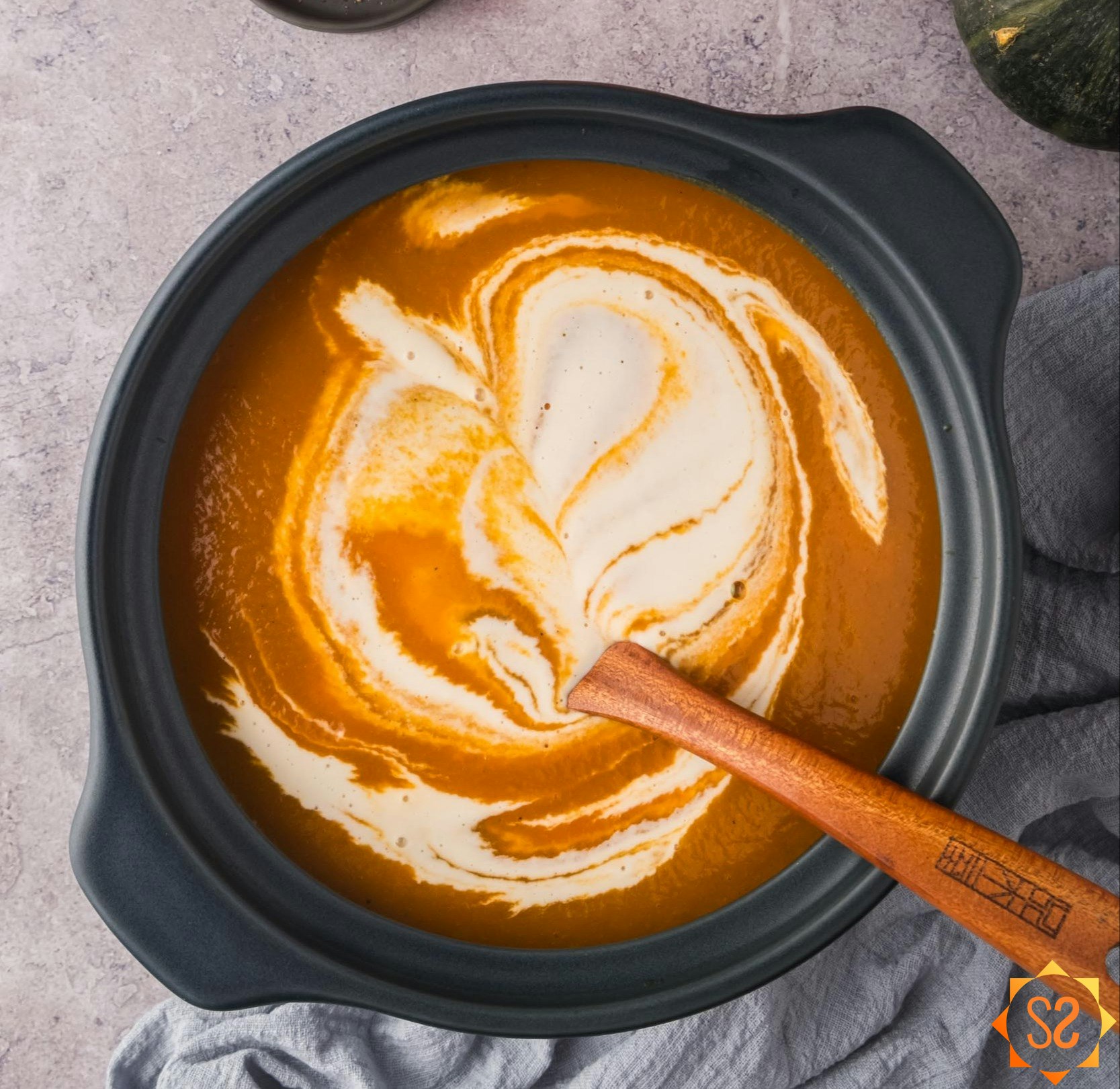 Stirring cashew cream into the carrot pumpkin soup.