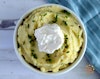 Vegan sour cream mashed potatoes in a bowl with chives and sour cream on top