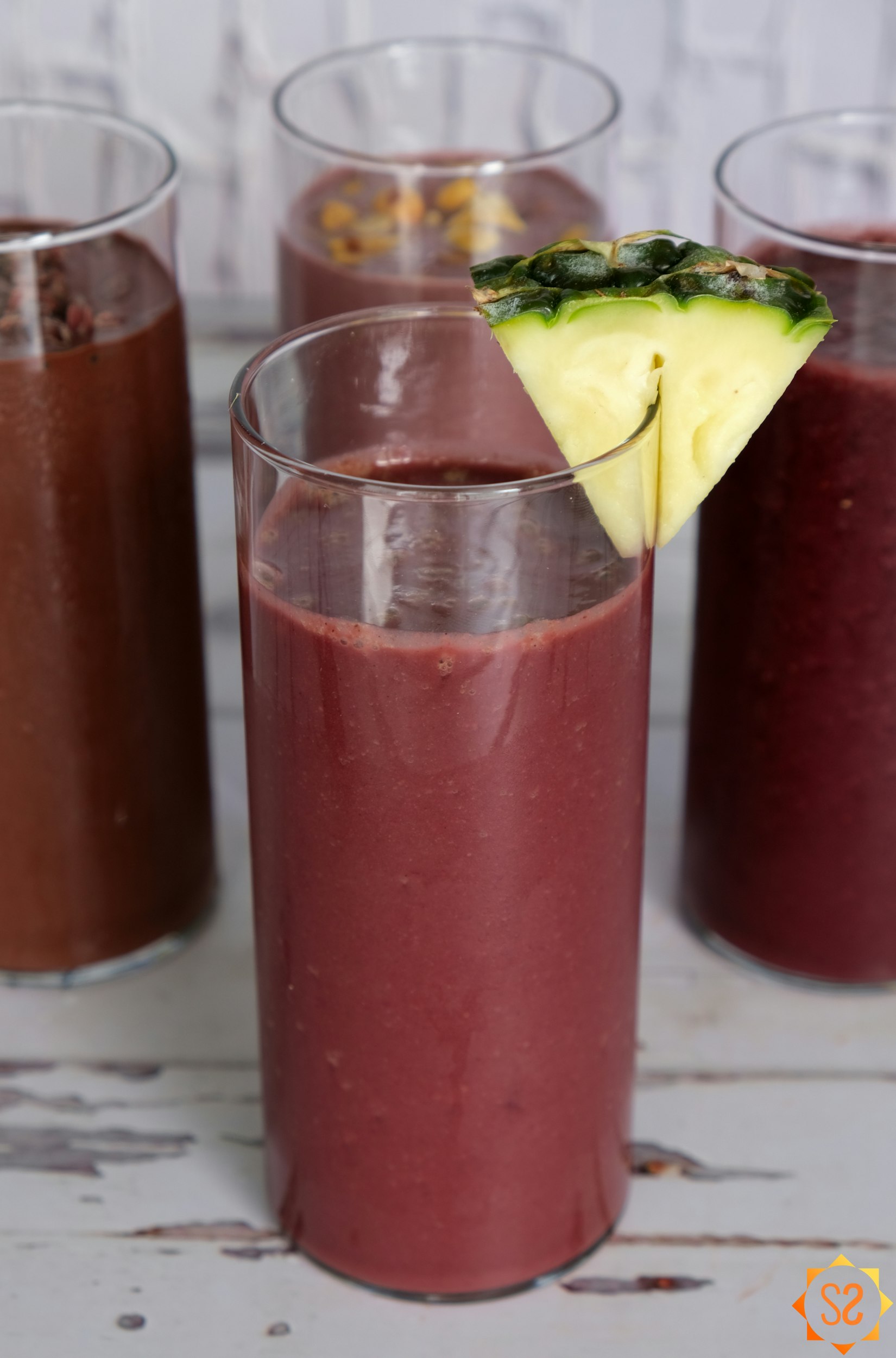 Pineapple-ginger Açaí smoothie surrounded by three other Açaí smoothies
