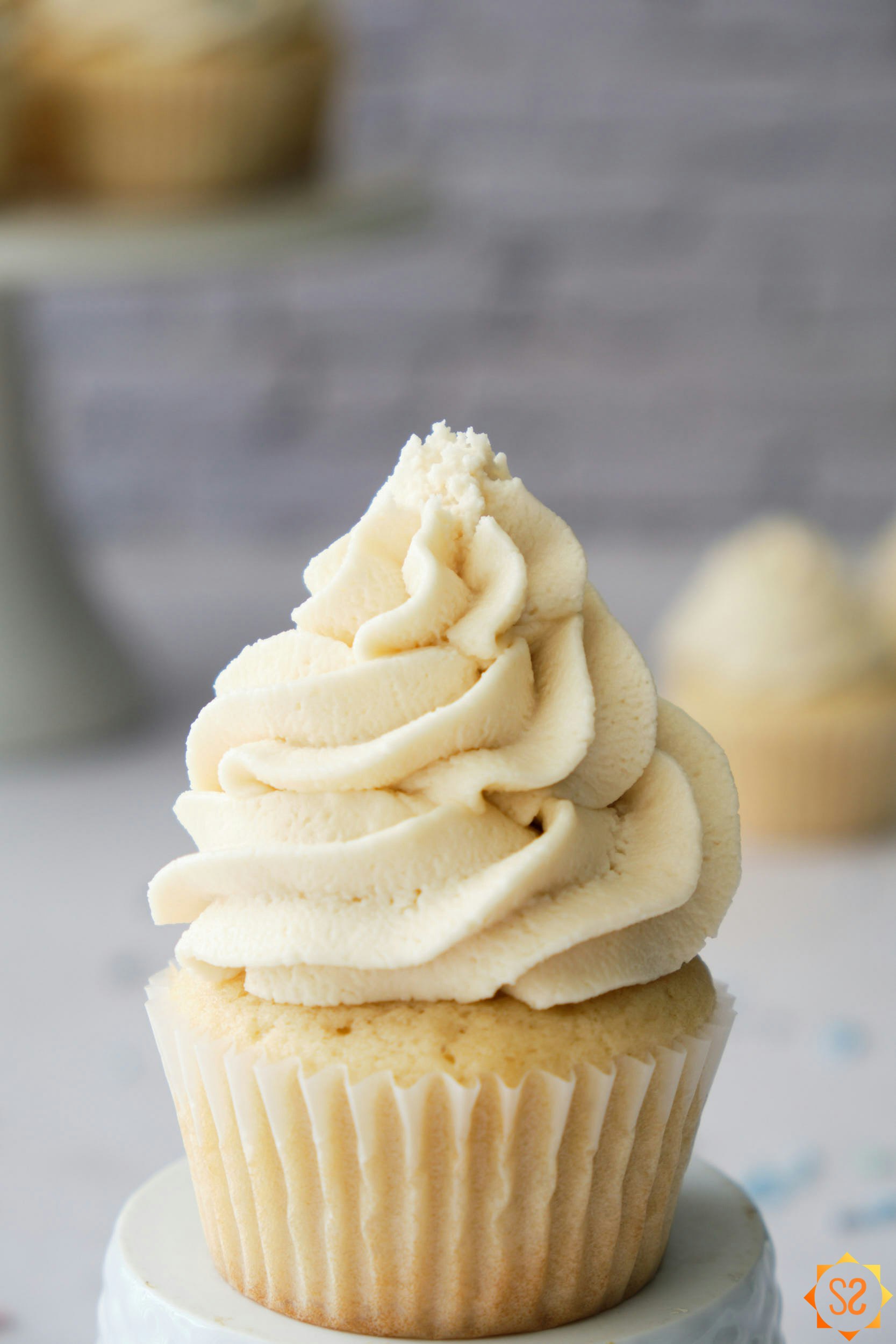 A close-up shot of a cupcake with vegan vanilla buttercream on top.