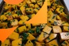 Butternut squash, cubed, on a baking tray with seasonings