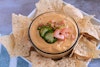 Vegan queso in a bowl surrounded by a plate full of tortilla chips