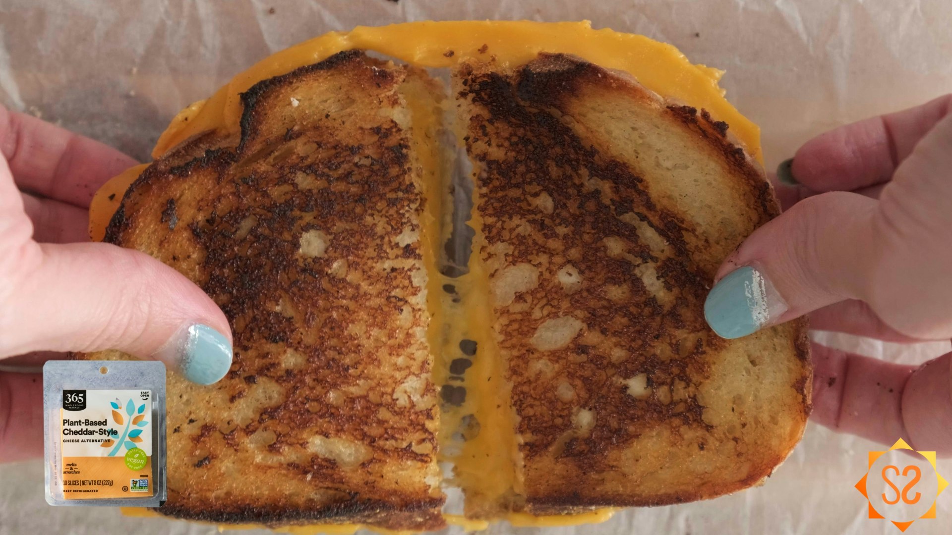 Hands pulling apart a grilled cheese sandwich made with 365 plant-based cheddar