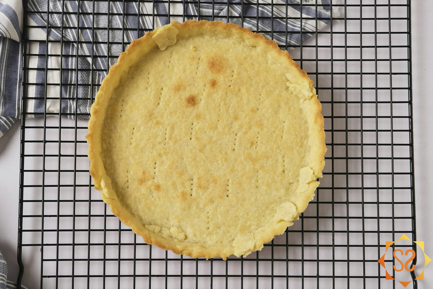 Baked tart crust cooling on a cooling rack.