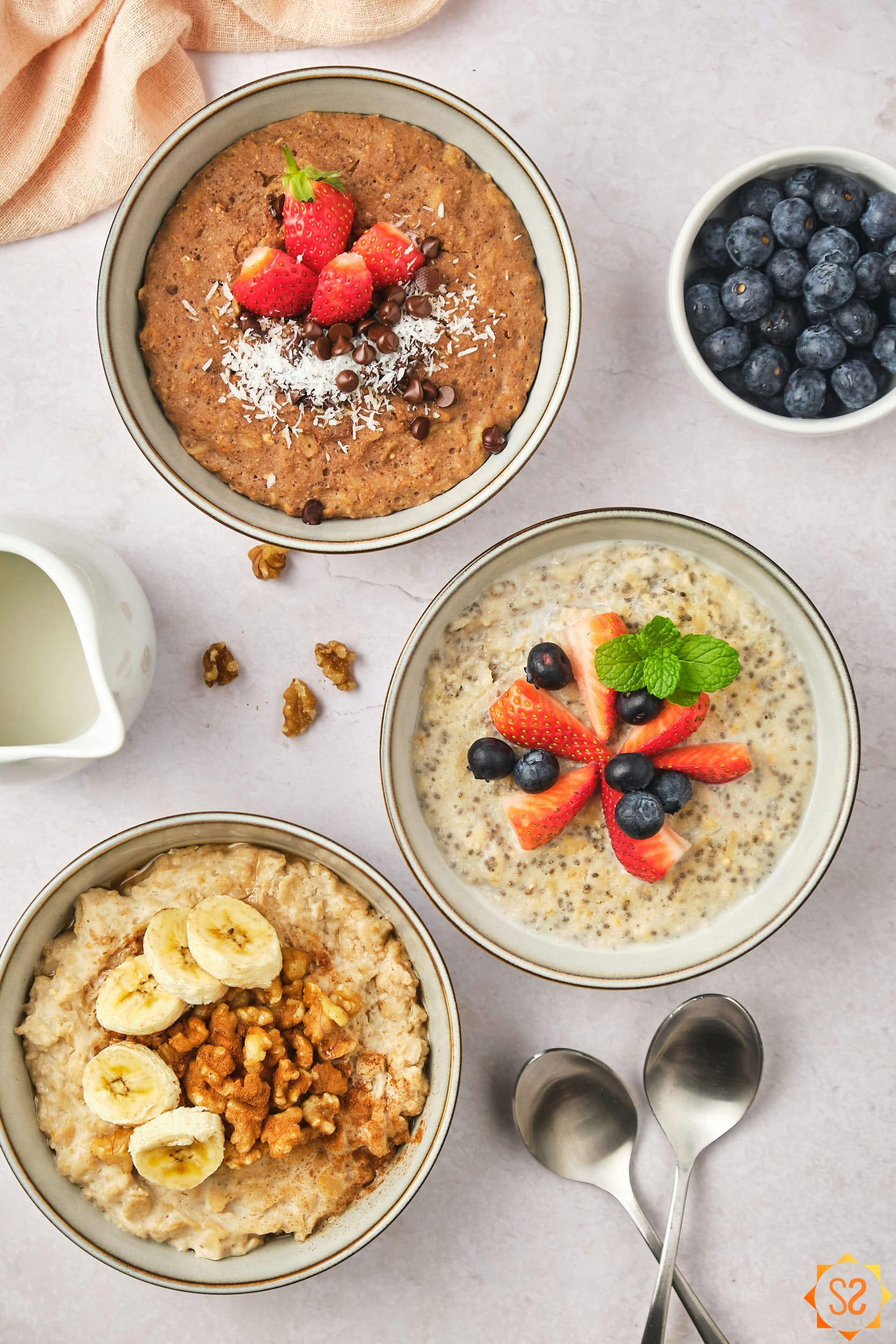 Three flavors of protein oatmeal (chocolate with coconut and strawberry, chia with strawberry and blueberry, and banana walnut peanut butter).