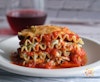 Vegan lasagna slice side view with wine