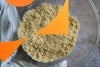 Flour and shortening mix in a bowl after being cut to a crumbly texture