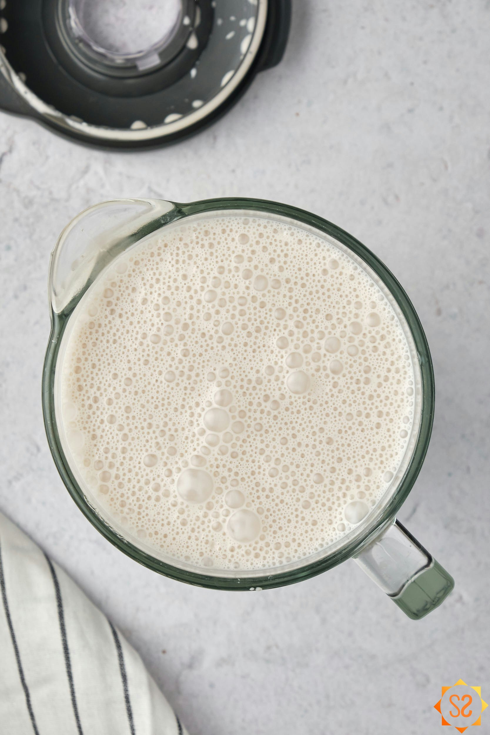 A top-down view of blended coquito in a blender pitcher.