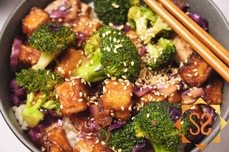 A close-up view of tofu stir fry in a bowl. 