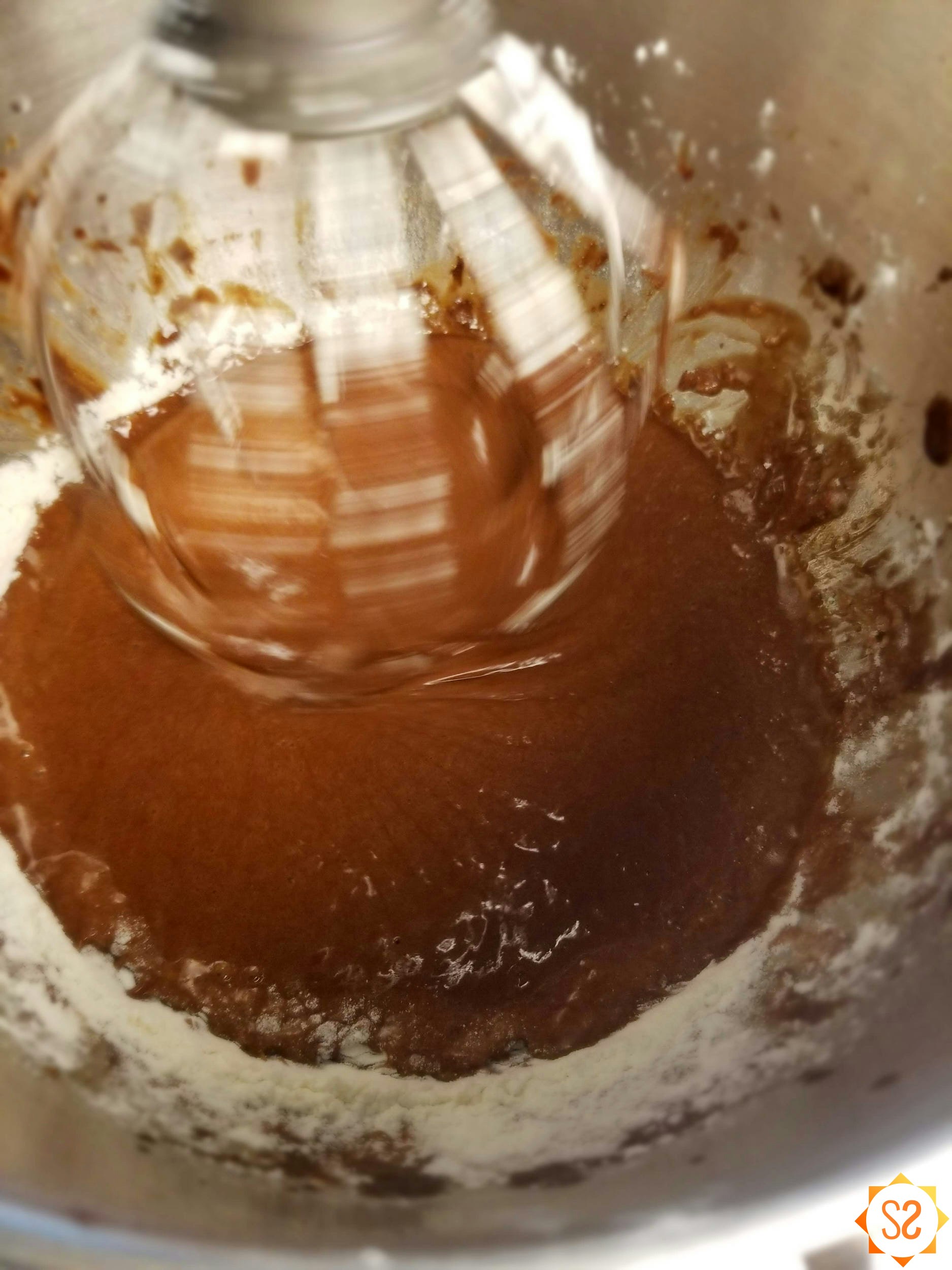 Chocolate cake batter being mixed in a mixing bowl.