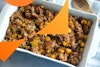 top down view of butternut squash stuffing in casserole dish with a wooden spoon on the side