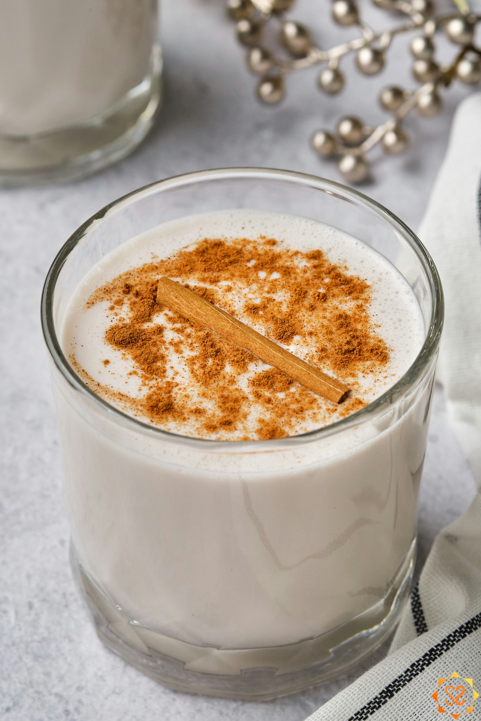 A close-up view of a single glass of vegan coquito.