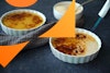 a torch caramelizing sugar on a vegan creme brulee dish; in the background are a bowl of sugar and a finished creme brulee dish