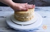 Gently pressing to remove space between frosting and cake.