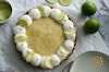 A vegan key lime pie garnished with non-dairy whipped cream, lime zest and lime slices
