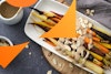 Roasted carrots on a platter with a cashew-tahini sauce and almond slices to the side