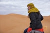 Steph riding a camel in the Sahara Desert