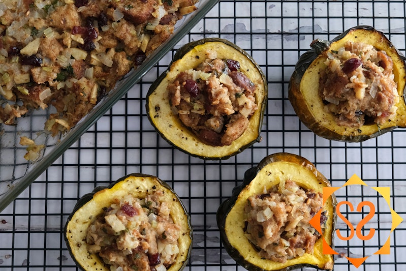 Cranberry apple vegan stuffing in acorn squash bowls with a dish of stuffing to the side