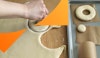 Hand cutting out a donut hole from dough, with one donut and one donut hole already cut on a baking tray on the side