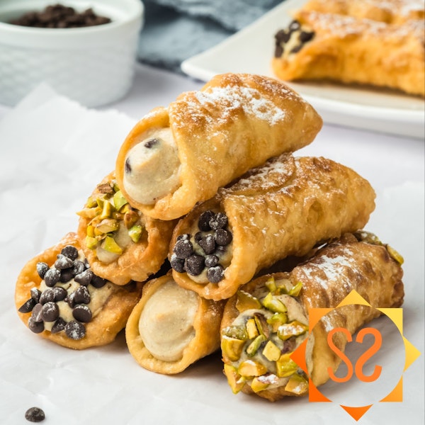 A stack of vegan cannoli on parchment paper.