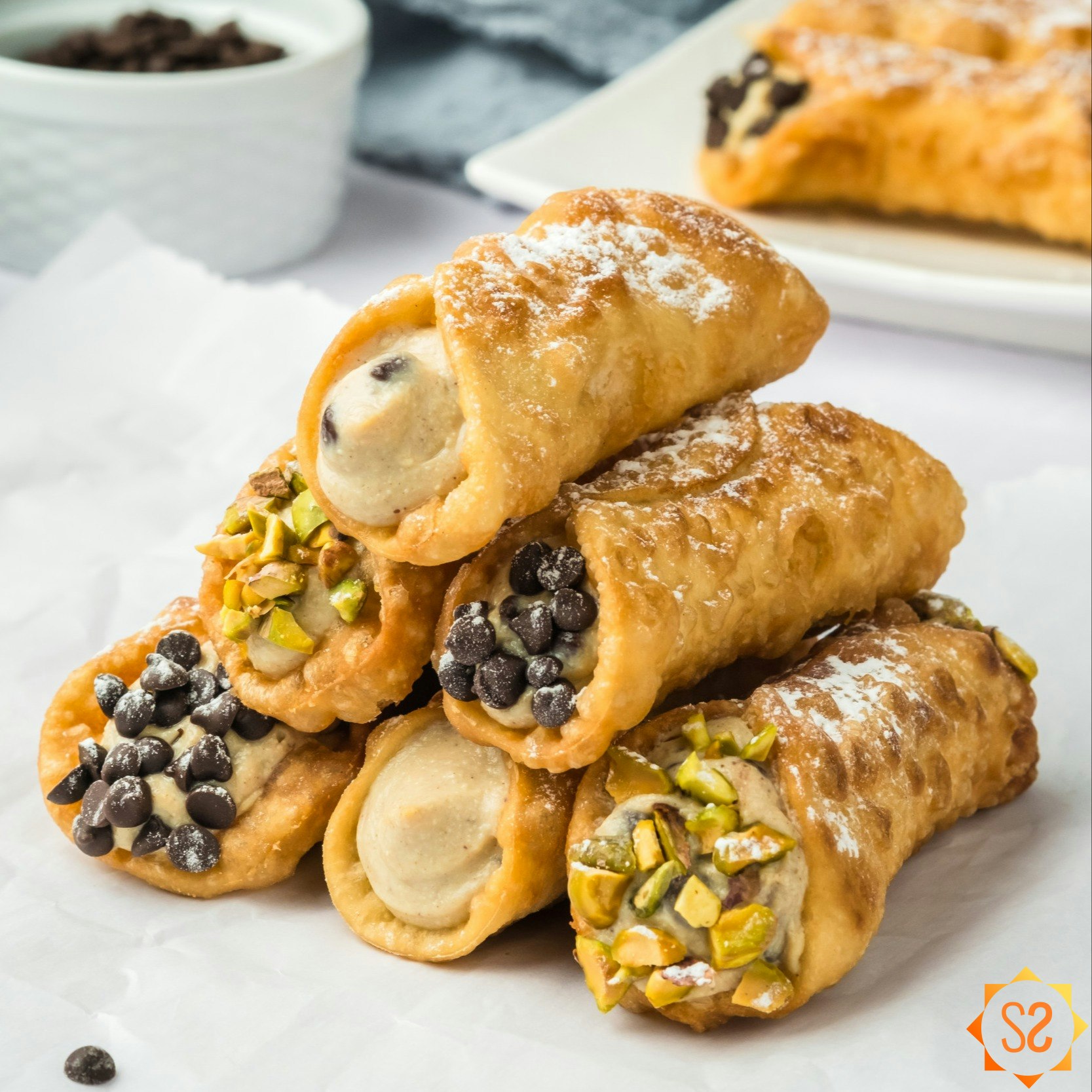 A stack of vegan cannoli on parchment paper.