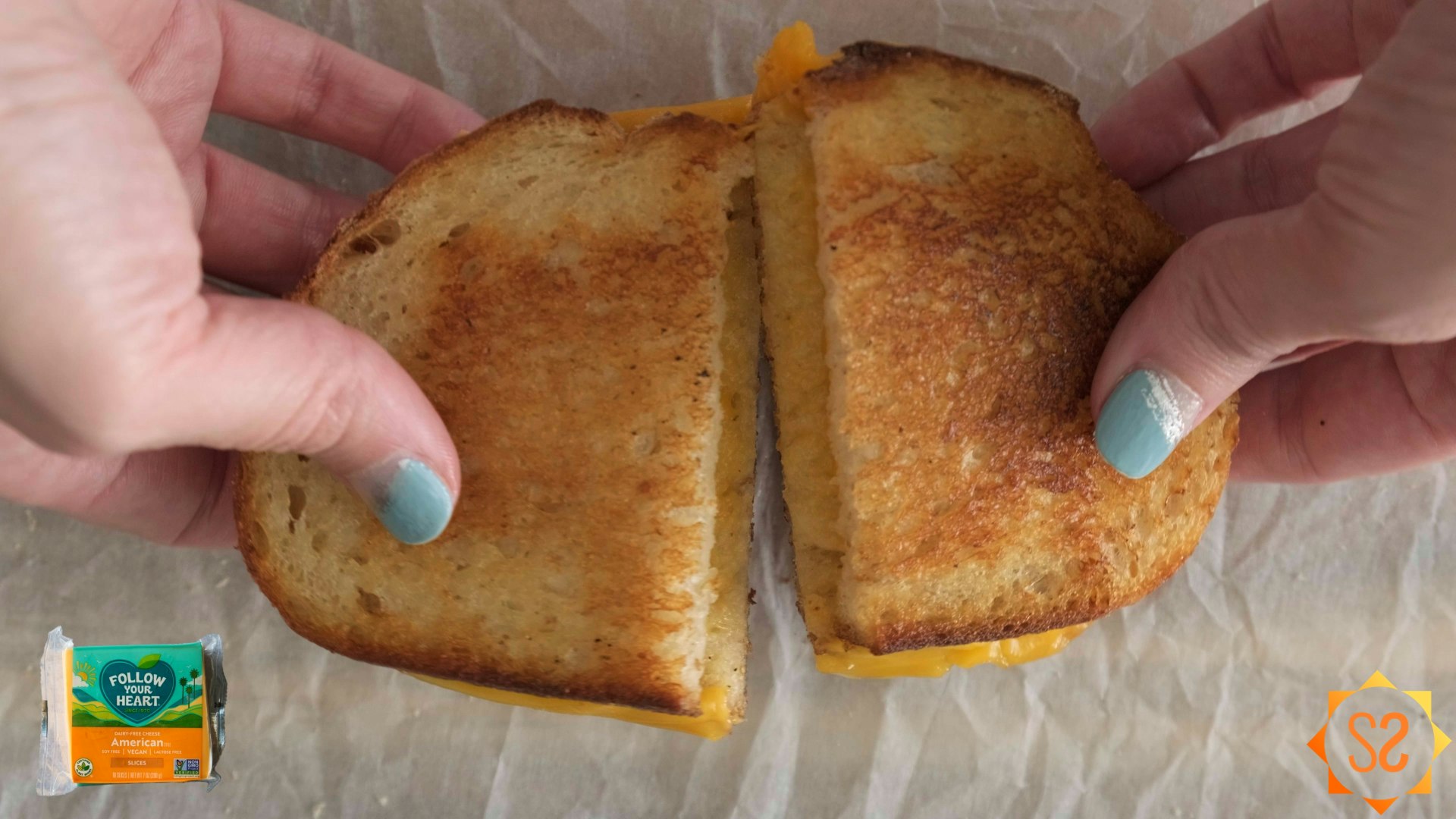 Two hands pulling apart a grilled cheese sandwich made with Follow Your Heart American
