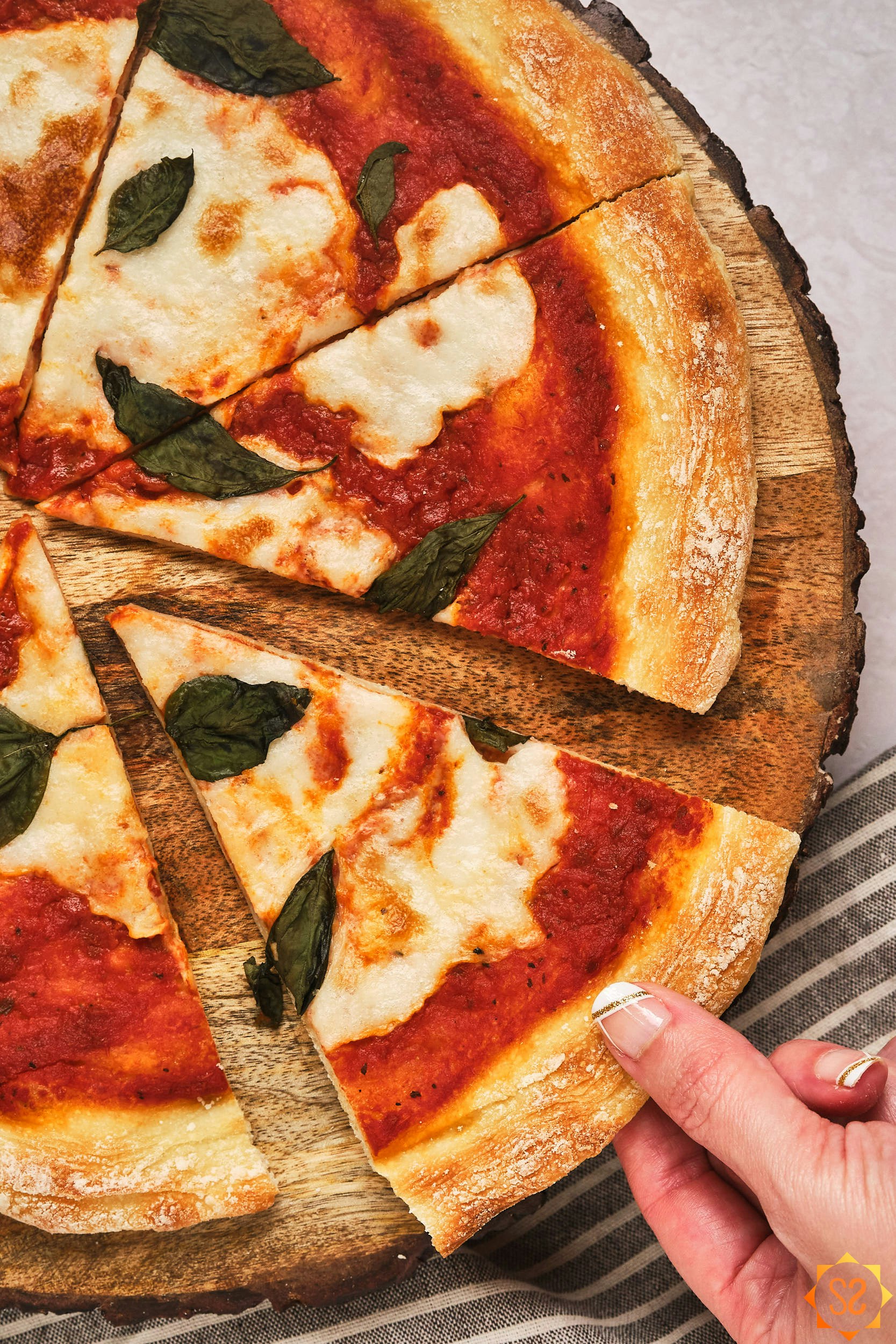 A hand grabbing a slice of vegan pizza made with vegan liquid mozzarella.