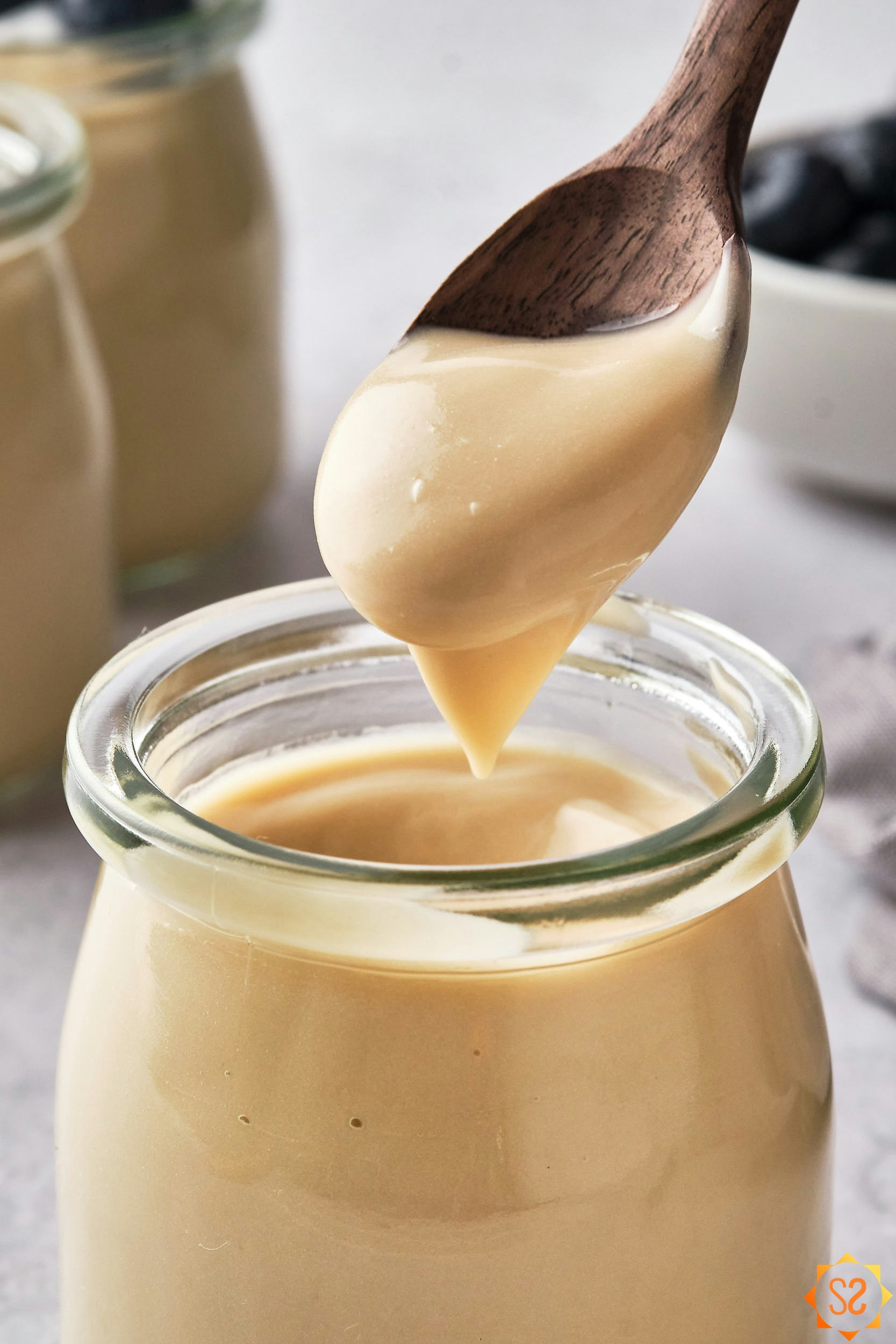 Vegan vanilla pudding being spooned out of a jar.
