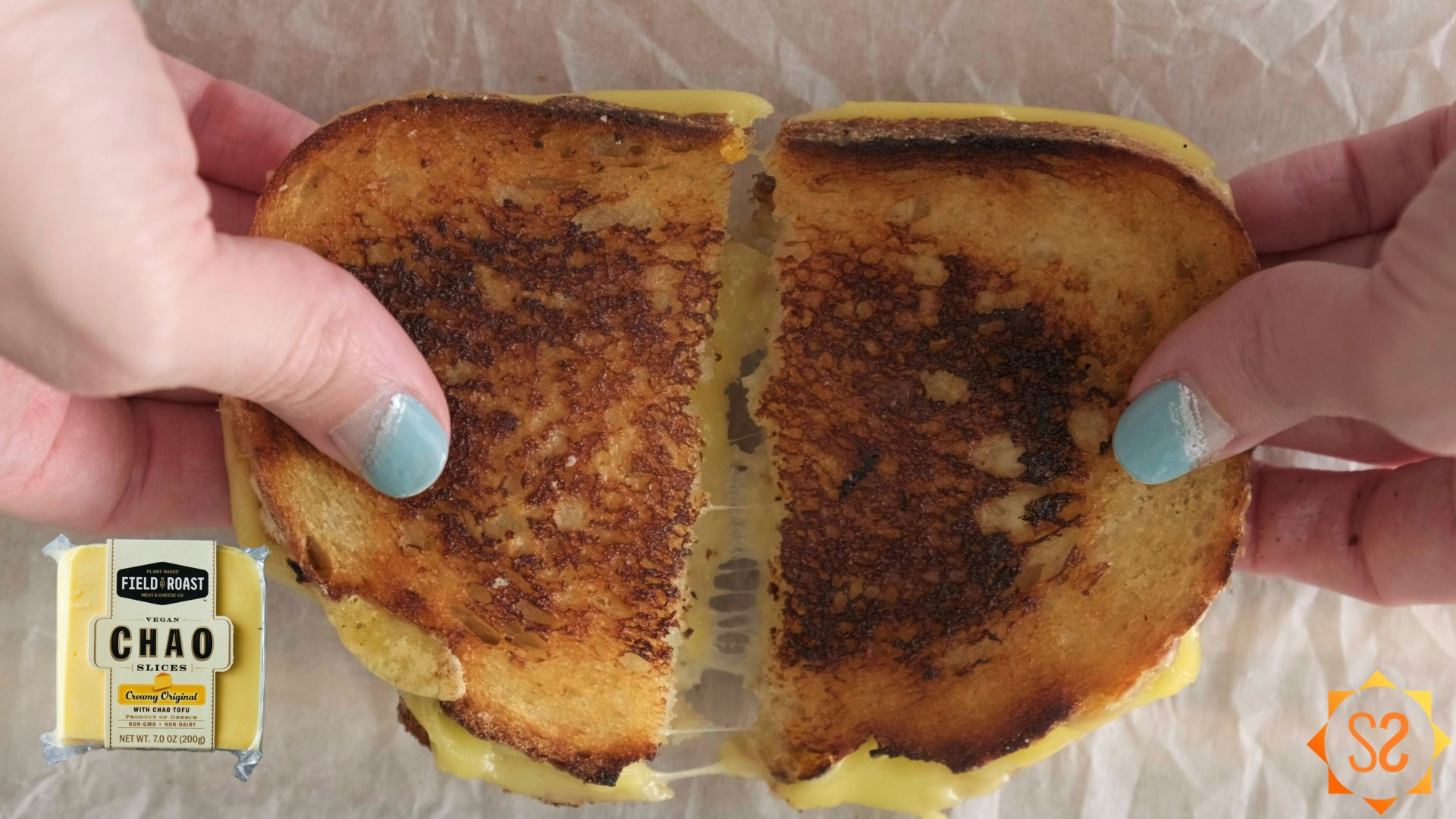 Two hands pulling apart a grilled cheese sandwich made with Chao creamy original