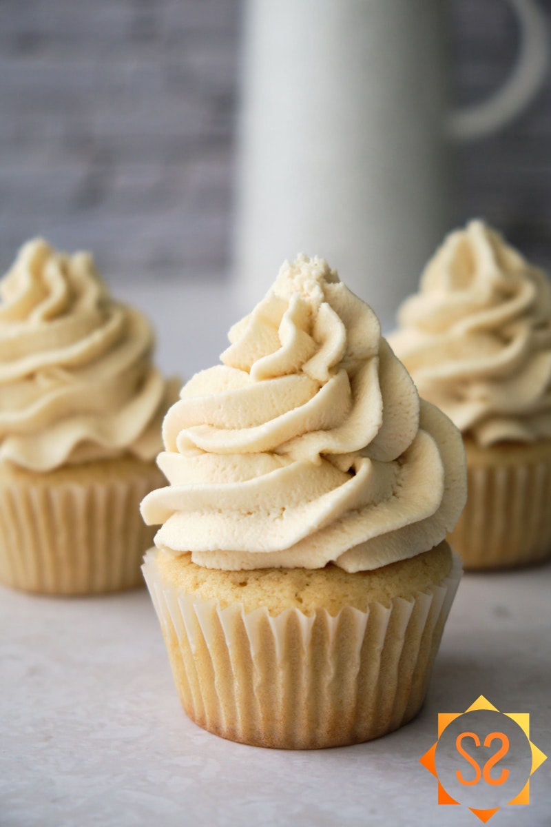 Three vanilla cupcakes topped with vegan buttercream frosting