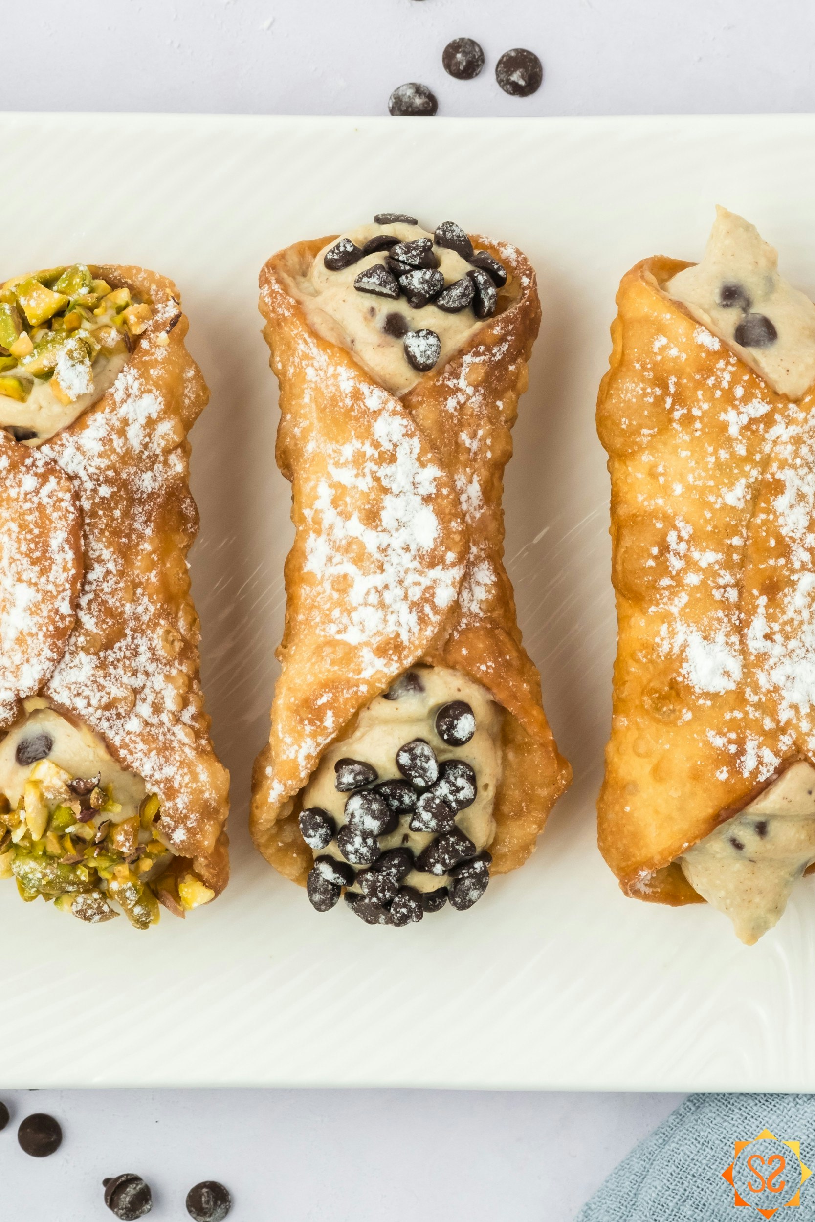 A top-down close up view of three cannoli.